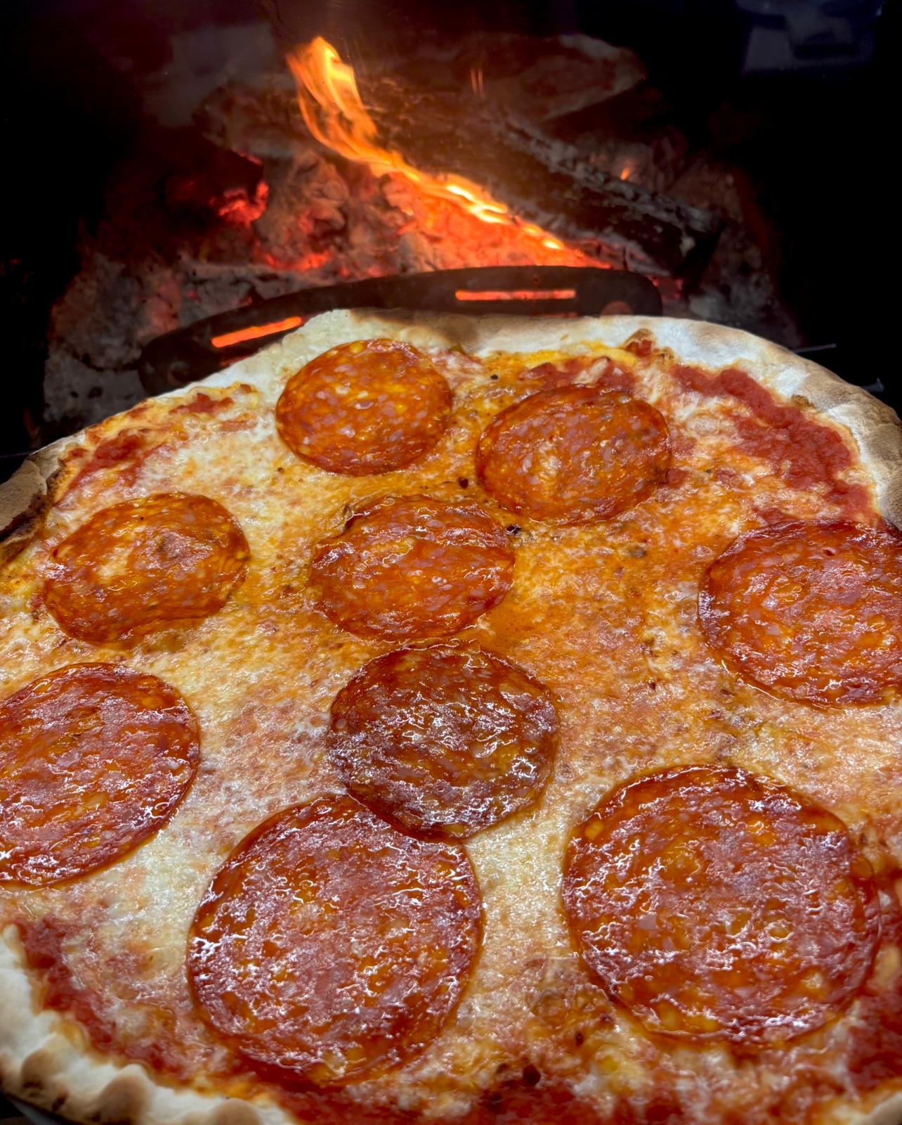 Pizza al salame piccante nel forno a legna
